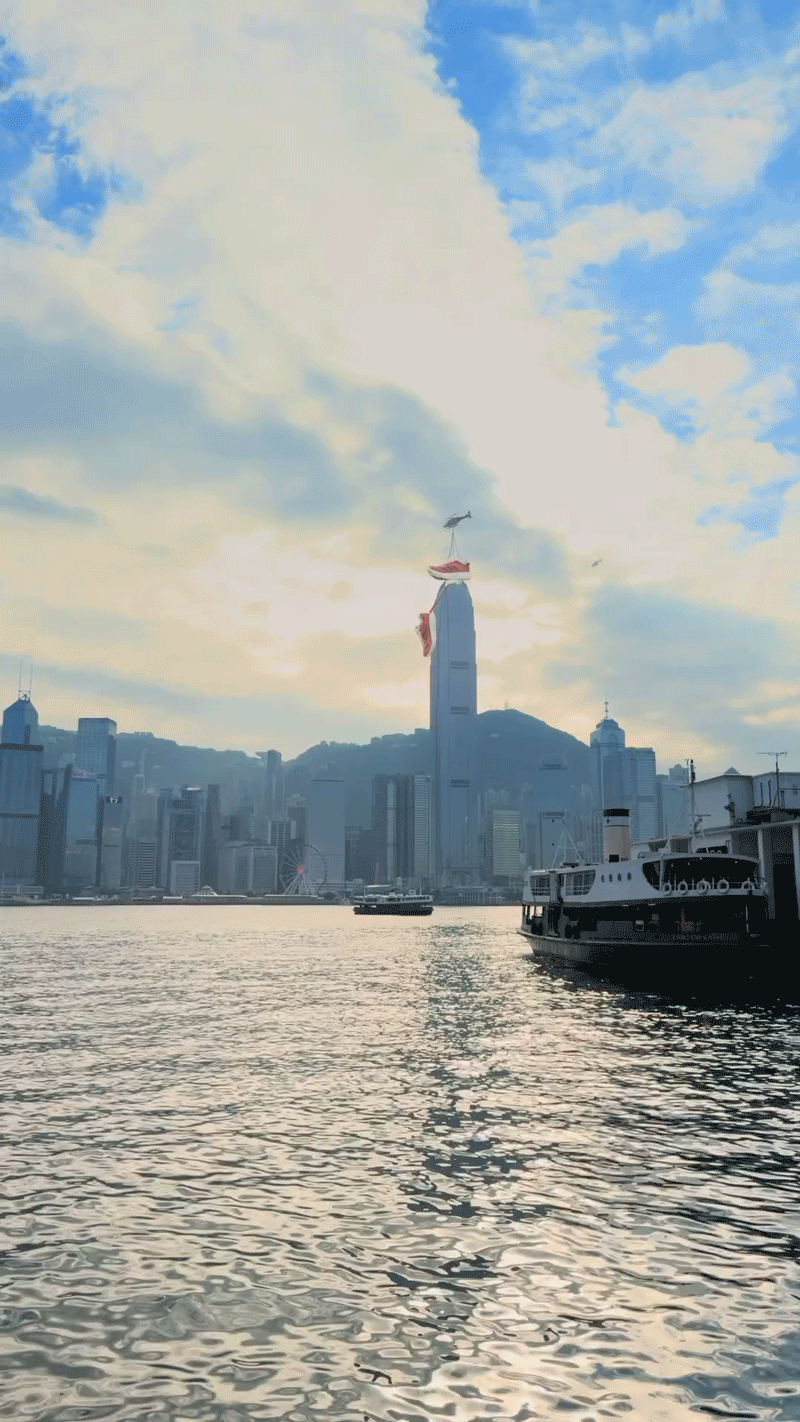 遠處的直升機把中環大廈上其中一隻巨型Adidas運動鞋運走。
