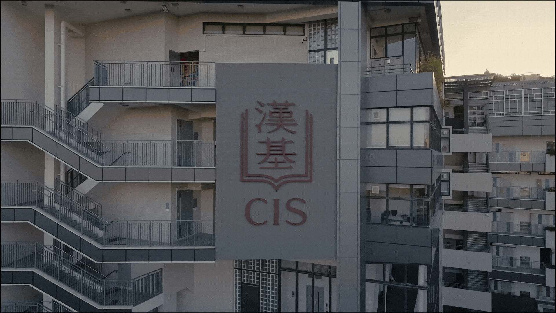 先以航拍鏡頭拍攝學校標誌，再高速移動至新校舍。